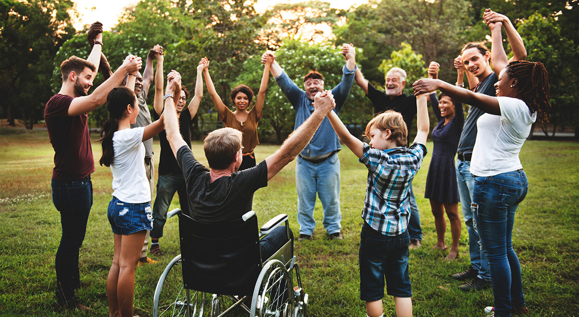Diverse group holding hands in circle outside