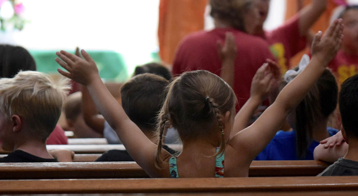 Stock girl sitting in church pew vacation bible school vbs